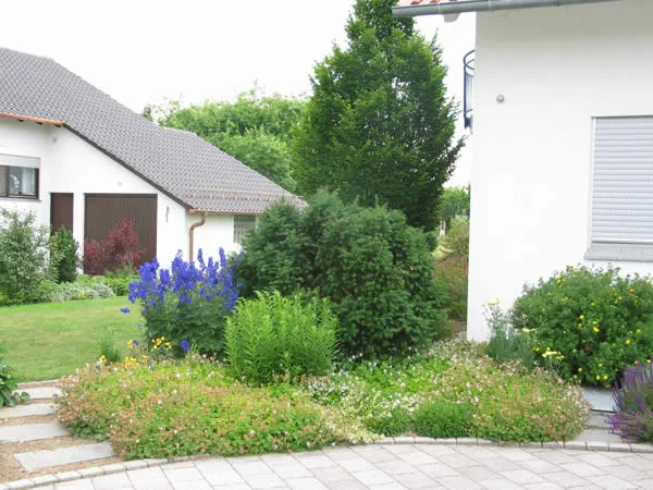 Hausgarten mit Staudenbeeten und geschwungenem Weg