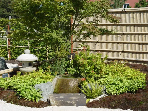 Wasserlauf mit Natursteinen im angelegten Garten