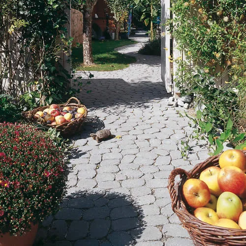 Gartenweg aus Betonpflaster zwischen Beeten